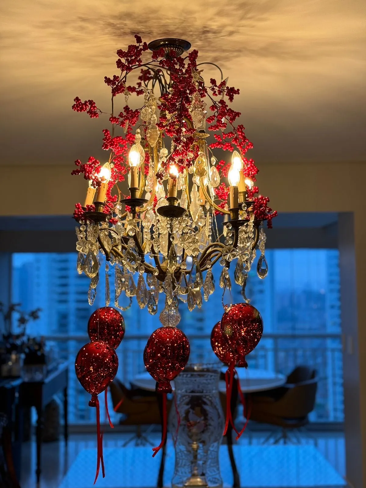 Lustre decorado com ramos e grandes bolas natalinas vermelhas